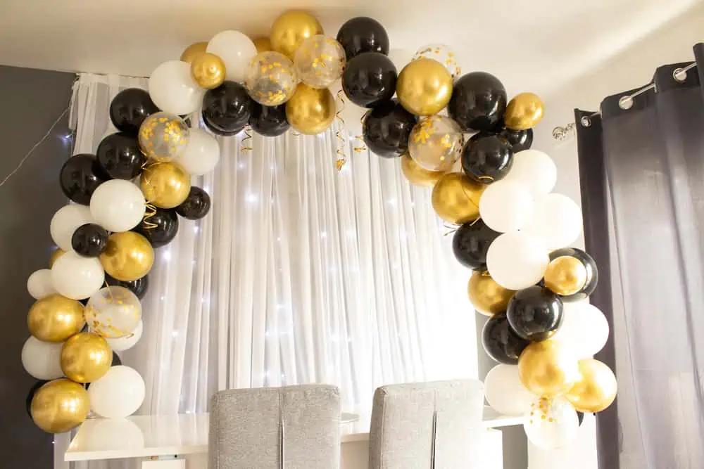 Black, yellow, and white balloon arch with white curtain casino party rentals vegas concepts